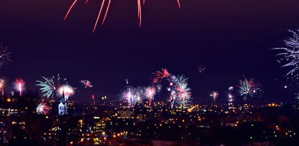 Vibrant fireworks light up the night sky over a city. Perfect for celebrations or festive events.