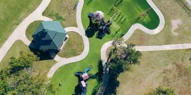Aerial view of a playground with green lawns and pathways.