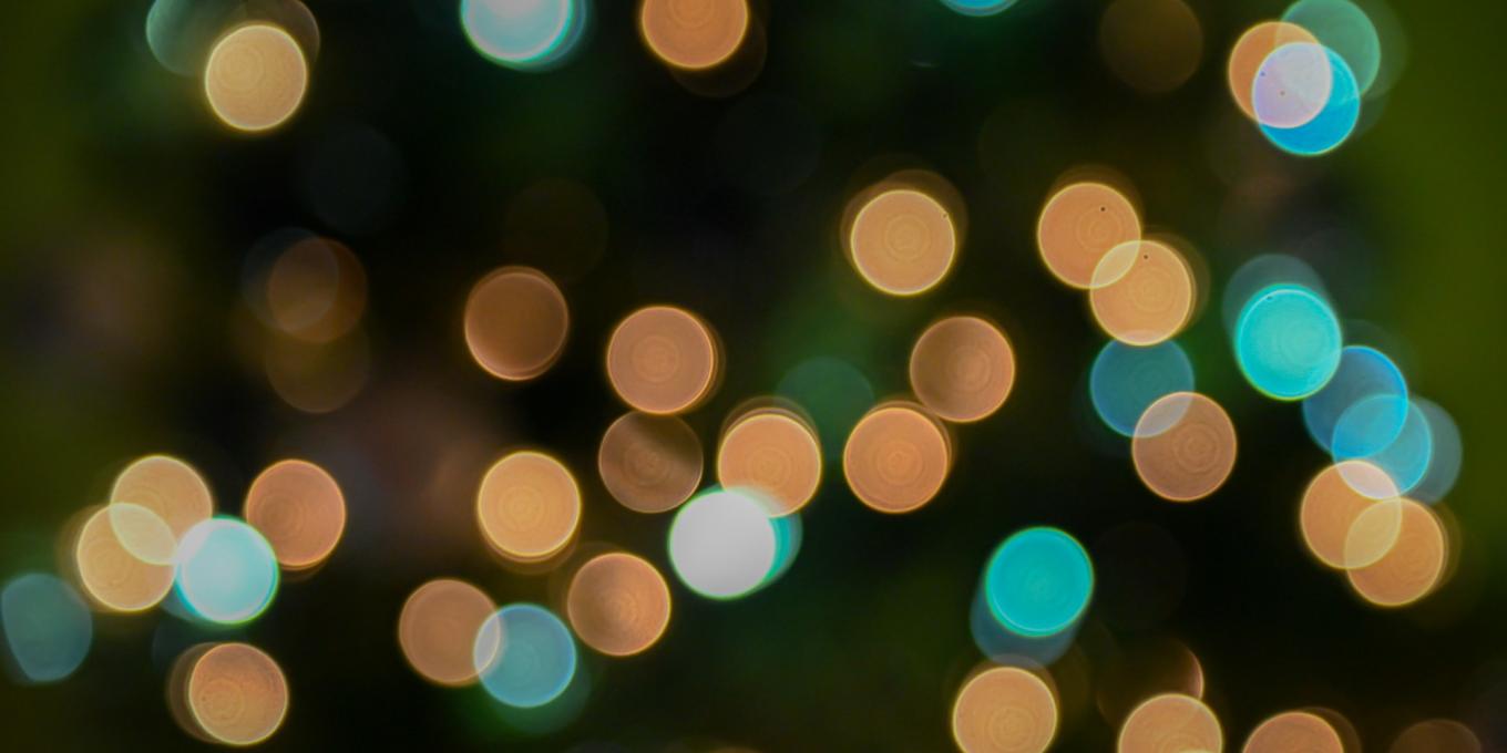 Colorful bokeh lights in blue and gold against a dark background.