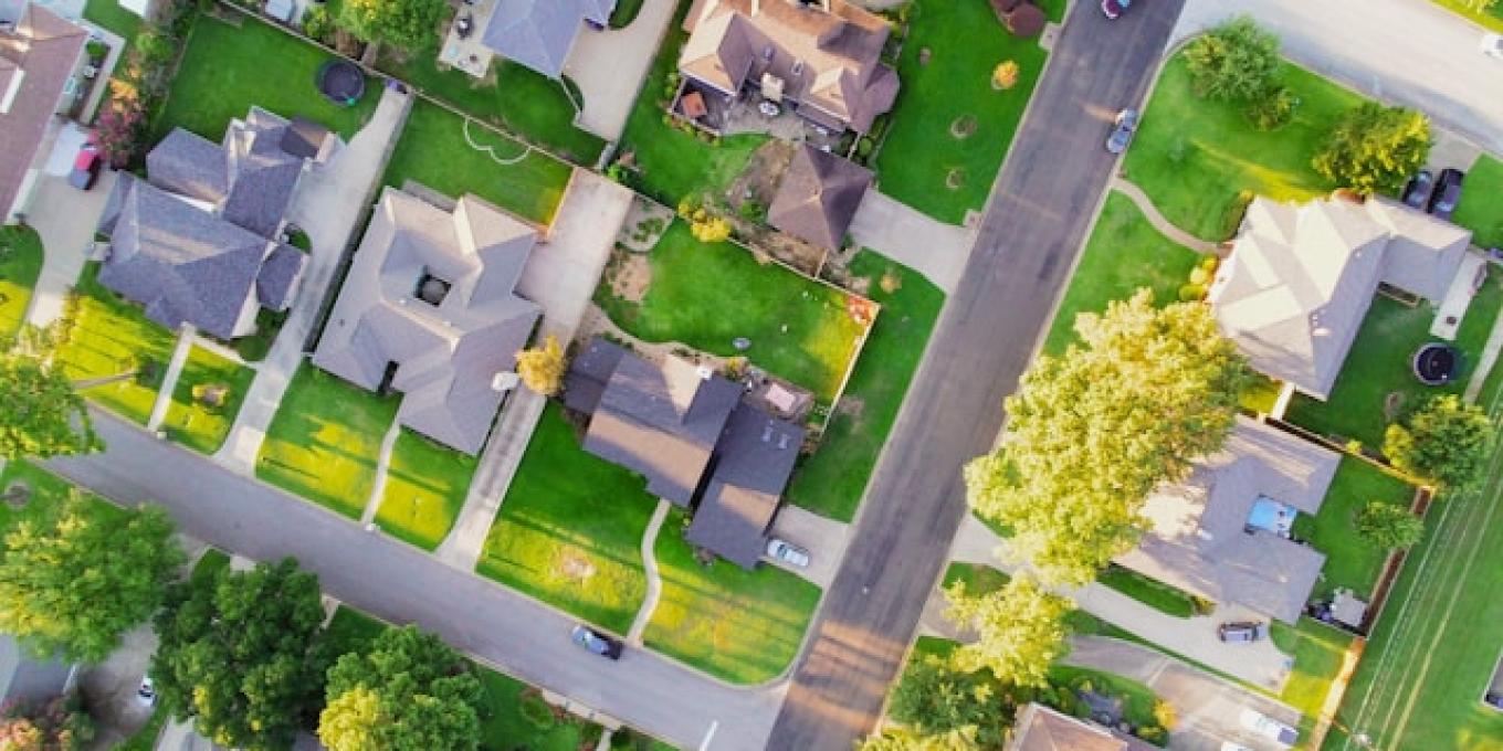 Aerial view of suburban neighborhood with houses and green lawns.