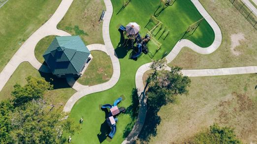 Aerial view of a playground with green lawns and pathways.